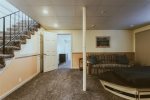Den features TV, bar area, and additional seating area for gathering